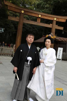 El novio viste el traje ‘montsuki’ en la entrada del templo Mengi Jingu