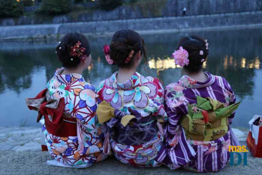 Tres invitadas vestidas con kimonos estampados.