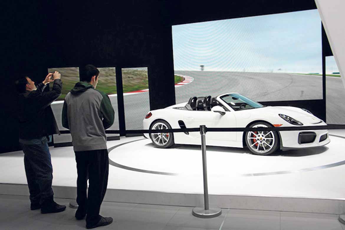 Dos visitantes admiran el Porsche Cayman 2015.