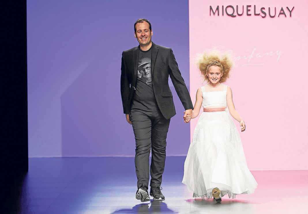 El diseñador Miquel Suay con una de las pequeñas modelos en la última Barcelona BridalWeek. BARCELONA BRIDALWEEK