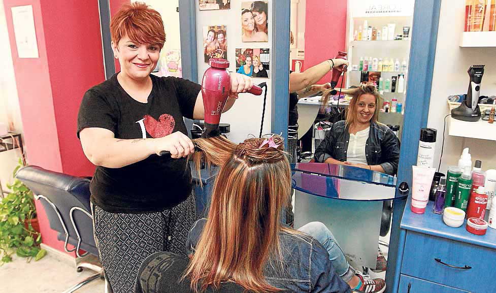 Patricia Clapés peina a una clienta en su peluquería de Vila. RUBÉN E. IBAÑEZ