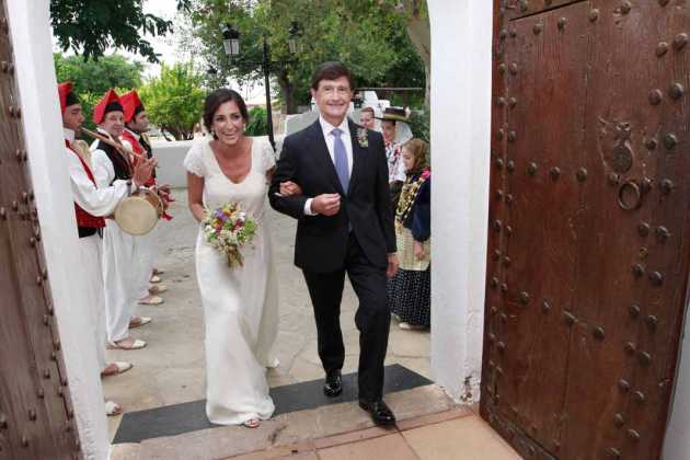 La novia con el padrino a la entrada de la iglesia de Jesús.