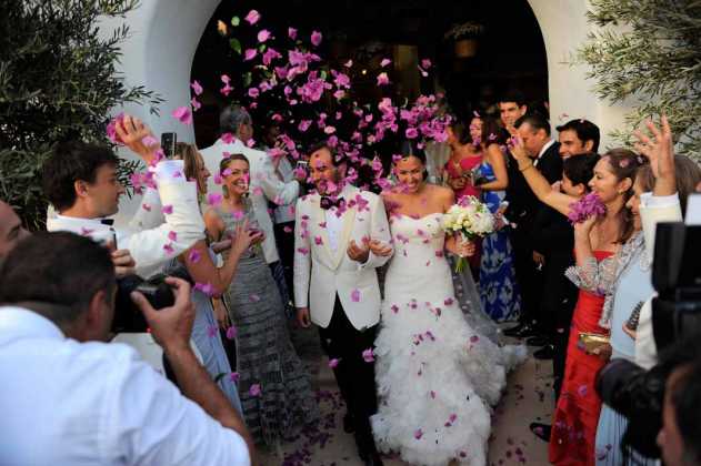 Los invitados felicitan con pétalos de flores a los recien casados a la salida de la parroquia.