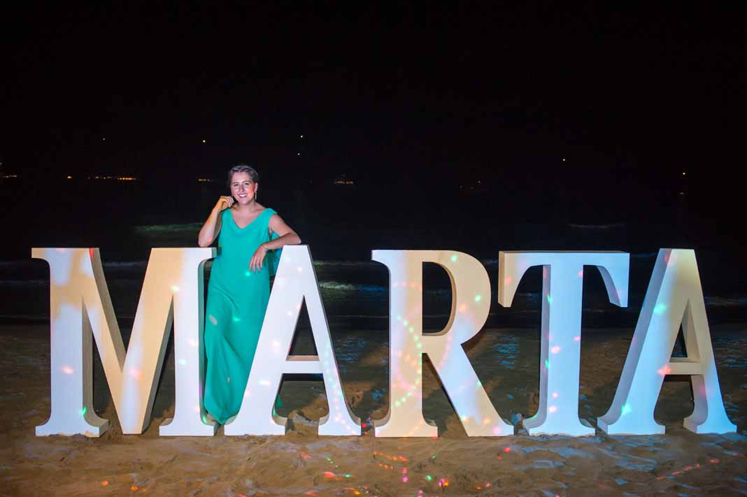 Marta Pérez Maura posa ante el cartel situado en la playa con su nombre y efectos especiales. FOTOS SERGIO CAÑIZARES.