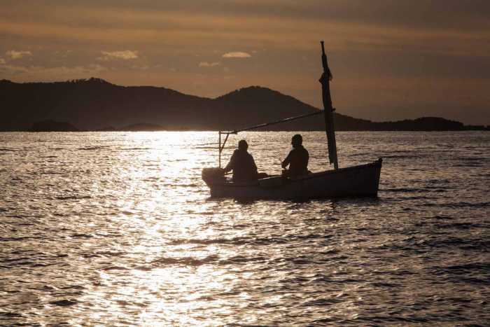 Dos pescadores en un ‘llaüt’ practican la pesca con potera de calamares. VICENT MARÍ