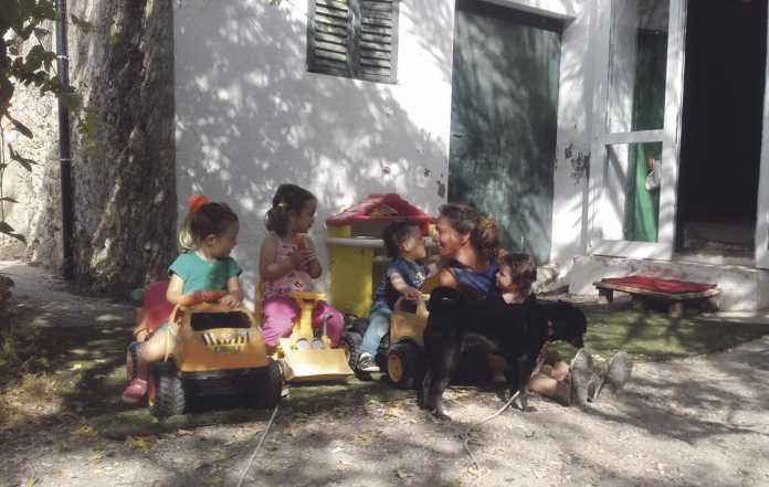 La madre de día Sandra Vericat junto a los cuatro críos que cuida y su perra Mica, en la puerta de su casa de campo. FOTOS J.LA.