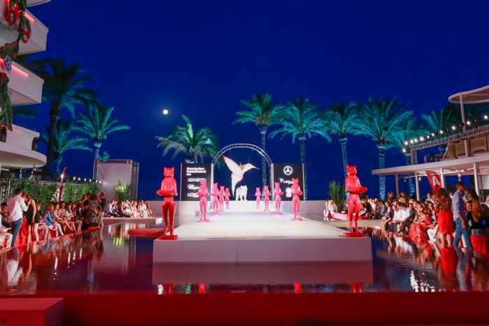 Vista del escenario de moda al caer la noche y con la luna llena al fondo impregnando de magia y color el evento.