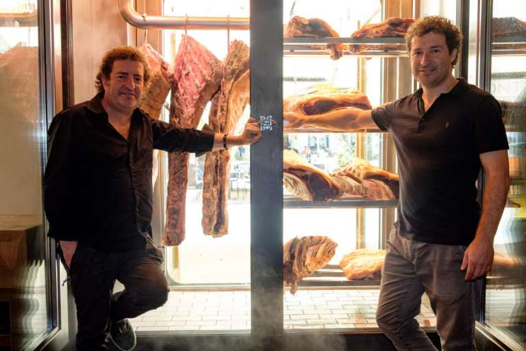 Los chefs Iñaki y Mikel Lz de Viñaspre ante el frigorifico especial de las carnes. Sagardi en Café Montesol