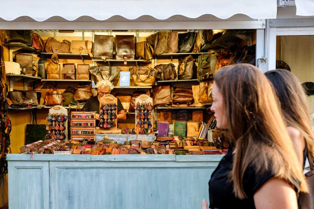 Un grupo de mujeres que visita la feria pasa por delante de un puesto de artículos de cuero. Fotos: Sergio G. Cañizares